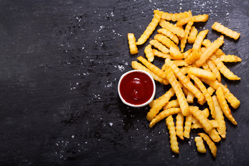 Wall Mural - French fries with ketchup on dark table