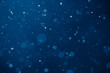 © nikkytok - blue light background with snowflakes particles