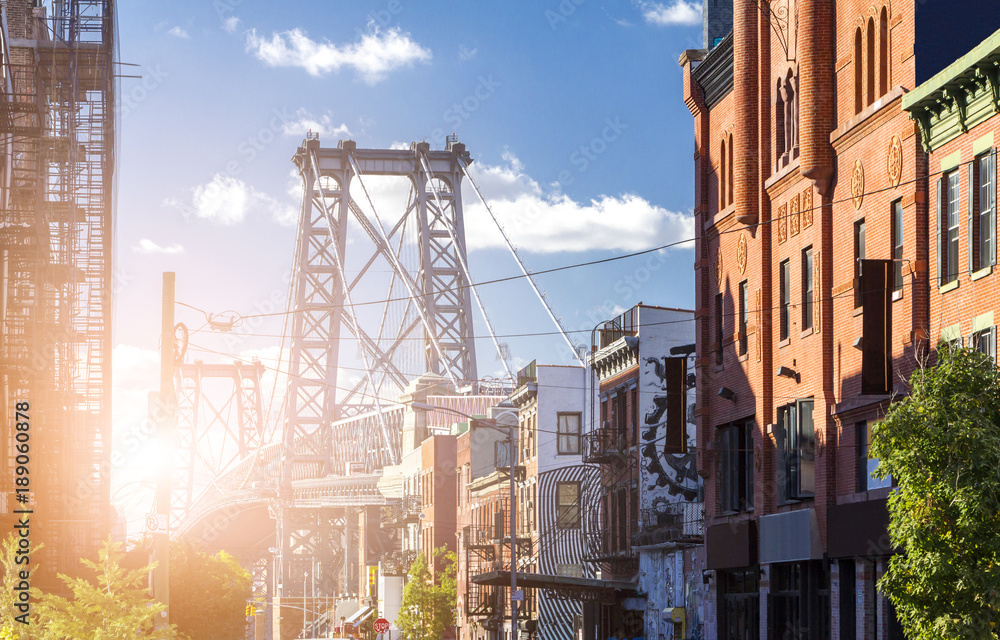 New York City street scene with sunlight shining on the Williamsburg Bridge in Brooklyn - obrazy, fototapety, plakaty 