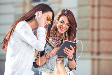 Two happy women are having fun together in the city.