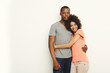 Smiling black couple in casual embracing at white studio background