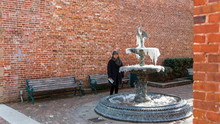 Asian Woman Standing By Frozen Fountain