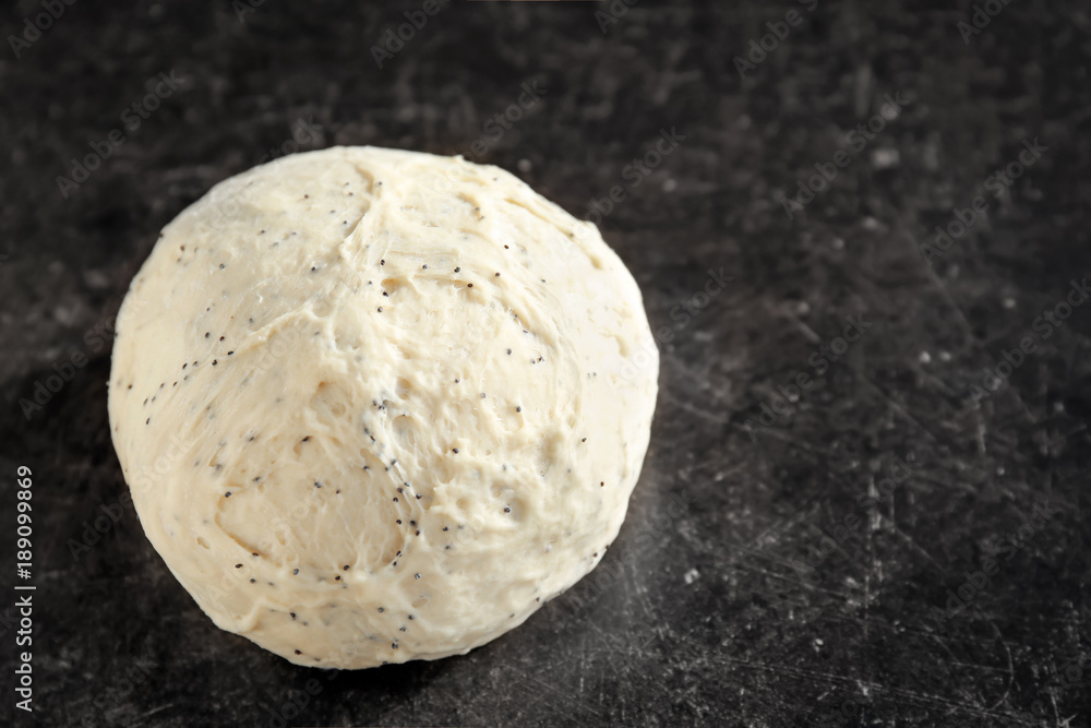 Raw dough with poppy seeds on table