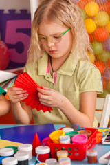 school children in kids hands cutting paper with teacher in class room. project in kindergarten. lar