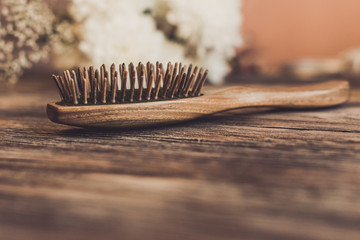 Wall Mural - Haircare concept. Natural sandalwood comb closeup on wood background