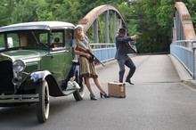 Two Models Get Dressed Up In 1930's Style  Vintage Fashion Clothes And Act The Role Of  The Gangster Duo Bonnie And Clyde.