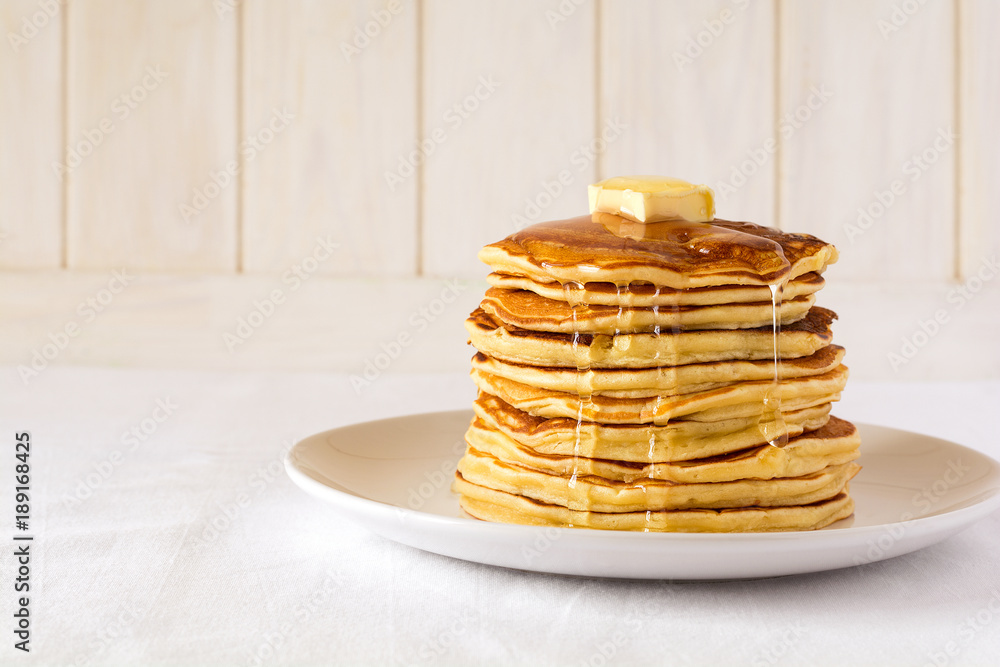 Stack of pancakes with butter and honey on white background - obrazy, fototapety, plakaty 