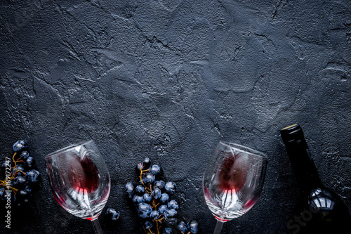 Plakat restauracja z butelką wina i winogron na widok z góry kamienia makiety