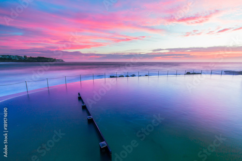 Zdjęcie XXL Różowy kolorowy wschód słońca nad Bronte skały basenem.