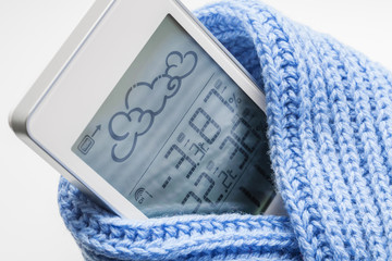 Wall Mural - Weather station device in the light blue knitted scarf on a light background. Closeup, selective focus