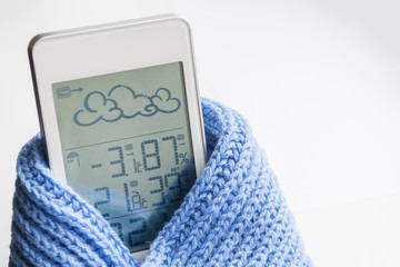 Wall Mural - Weather station device in the light blue knitted scarf on a light background. Closeup, selective focus
