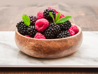 Wall Mural - Wooden cup with fresh berries on wooden table 