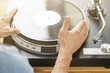 Hands placing record on turntable close-up, sun flare
