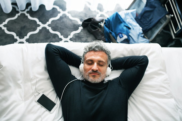 Wall Mural - Mature businessman with smartphone in a hotel room.