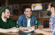 © Syda Productions - happy male friends drinking beer at bar or pub