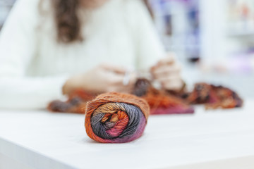 Wall Mural - close up of a brown wool of yarn while a woman is knitting