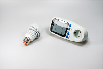 LED bulb and a consumption meter on a white background