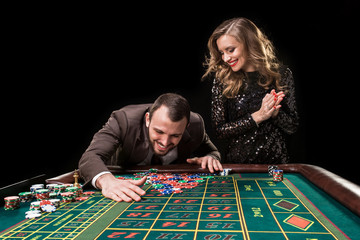 Man and woman playing at roulette table in casino