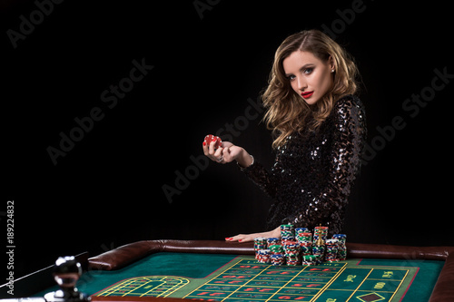 Fotomural Woman playing in casino. Woman stakes piles of chips playing rou
