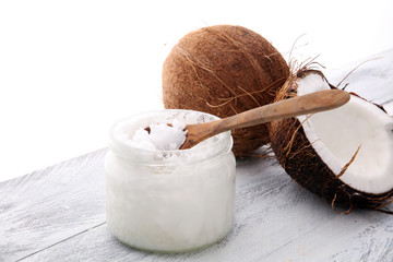 Wall Mural - coconut and opened glass jar with fresh coconut oil on wooden background.