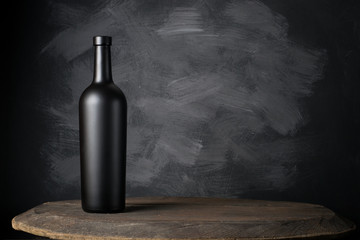 Wall Mural - Red wine bottle on a wooden background