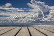 Holzboden mit Meer und blauem wolkigen Himmel im Hintergrund