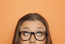 Half Portrait Of A Young Girl With Glasses Looking Up