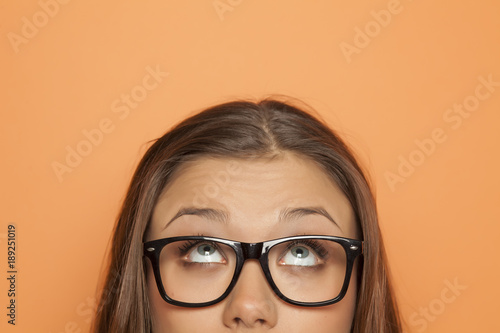 Fotografía half portrait of a young girl with glasses looking up
