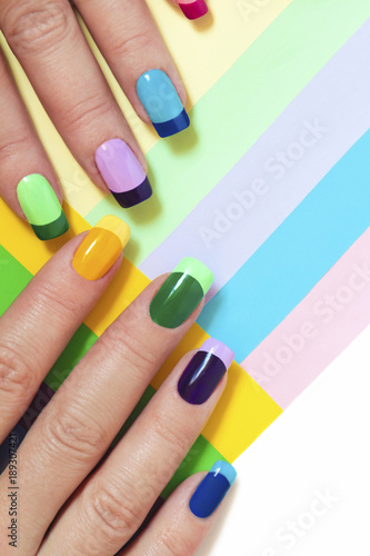 Fotografija Multi-colored pastel manicure combined tone on tone with a striped background