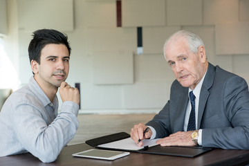 Wall Mural - Puzzled executive and assistant examining document