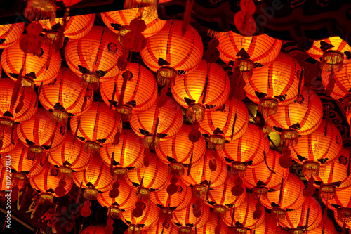 A Lot Of Lighted Chinese Paper Lanterns Hanging From The Ceiling