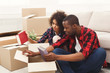 © Prostock-studio - Young balck couple unpacking moving boxes