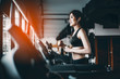 © Take Production - Portrait of Fitness woman running on treadmill in gym listening to music.exercising concept.fitness and healthy lifestyle.