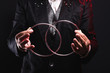 Magician shows trick with metal rings. Manipulation with props. Sleight of hand.