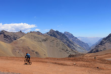 A Mand Biking Down The Valley In The Mountains In A Healthy Adventure