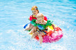 © famveldman - Kids on inflatable float in swimming pool.