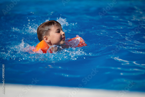 Plakat Kaukaski chłopiec pływanie w basenie.