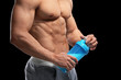 © Africa Studio - Handsome muscular young man with protein shake on black background, closeup