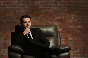 Canvas Print - Man in elegant suit on brick wall background