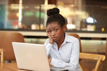 Wall Mural - African woman with laptop looking tired