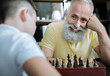 © zinkevych - Proud of him. Selective focus on an extremely happy elderly man looking at his grandson and grinning broadly while both playing chess game together.