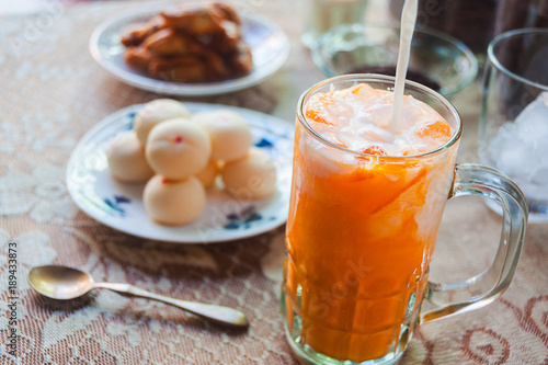Zdjęcie XXL Cha Tajlandzki, Tajlandzki lukrowy herbaciany dolewanie mleko na wierzchołku z talerzem tajlandzkiego mochi słodki deser na stole, selekcyjna ostrość