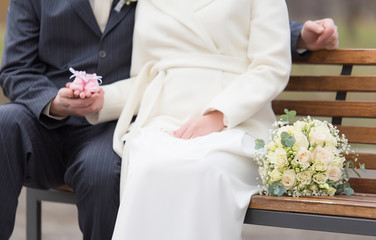 Wall Mural - Married couple walking in the park. Focus on wedding bouquet