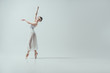 © LIGHTFIELD STUDIOS - attractive ballerina in white dress dancing in studio, isolated on white