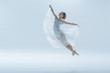 © LIGHTFIELD STUDIOS - elegant ballet dancer in white dress jumping in studio, isolated on white