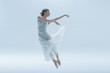 © LIGHTFIELD STUDIOS - young ballerina in white dress jumping in studio, isolated on white