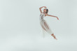 © LIGHTFIELD STUDIOS - elegant ballet dancer in white dress jumping in studio, isolated on white