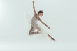 © LIGHTFIELD STUDIOS - beautiful ballet dancer in white dress jumping in studio, isolated on white