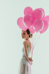 Wall Mural - elegant ballerina in white dress with pink balloons, isolated on white