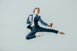 © LIGHTFIELD STUDIOS - businesswoman in suit and ballet shoes jumping with coffee and digital tablet, isolated on grey